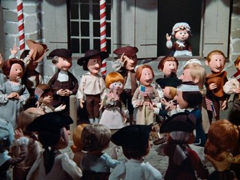 Movie still from “Rudolph's Shiny New Year” (1976), directed by Jules Bass – A group of people standing next to each other on a stage; Wide shot, High angle