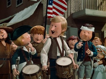 Movie still from “Rudolph's Shiny New Year” (1976), directed by Jules Bass – A group of people dressed in american clothing and playing drums; Medium shot, Low angle