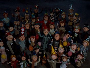 Movie still from “Rudolph's Shiny New Year” (1976), directed by Jules Bass – A large group of people that are all dressed up; Extreme Wide shot, High angle