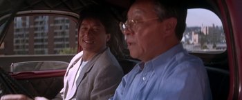 Movie still from “Rumble in the Bronx” (1995), directed by Stanley Tong – Two men sitting in the back seat of a car; Close Up shot, Low angle