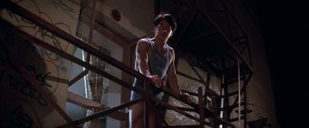 Movie still from “Rumble in the Bronx” (1995), directed by Stanley Tong – A man standing on top of a metal railing; Medium shot, Low angle