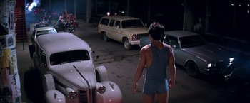 Movie still from “Rumble in the Bronx” (1995), directed by Stanley Tong – A man standing in front of a white truck; Wide shot, Over the shoulder angle