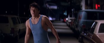 Movie still from “Rumble in the Bronx” (1995), directed by Stanley Tong – A man in a blue tank top is running; Medium shot, Low angle