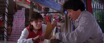 Movie still from “Rumble in the Bronx” (1995), directed by Stanley Tong – A woman and a man at a table with food; Medium shot, Over the shoulder angle