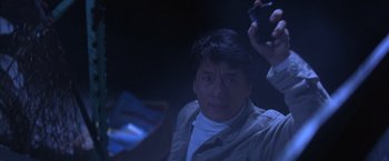 Movie still from “Rumble in the Bronx” (1995), directed by Stanley Tong – A man holding up a camera in a dark room; Close Up shot, Low angle