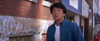 Movie still from “Rumble in the Bronx” (1995), directed by Stanley Tong – A man standing in front of a building with graffiti on the wall; Close Up shot, Low angle