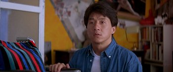 Movie still from “Rumble in the Bronx” (1995), directed by Stanley Tong – A man in a blue shirt is sitting at a table; Close Up shot, Low angle