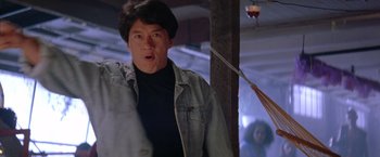 Movie still from “Rumble in the Bronx” (1995), directed by Stanley Tong – A man in a black shirt and a blue jean jacket; Close Up shot, Low angle