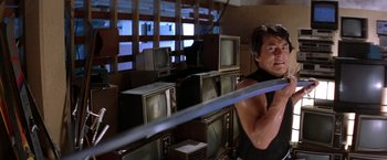 Movie still from “Rumble in the Bronx” (1995), directed by Stanley Tong – A man standing in front of a bunch of old tvs; Medium shot, Low angle