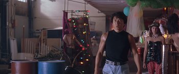 Movie still from “Rumble in the Bronx” (1995), directed by Stanley Tong – A man standing next to a christmas tree in a living room; Medium shot, Low angle