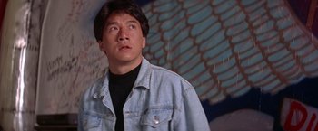 Movie still from “Rumble in the Bronx” (1995), directed by Stanley Tong – A man wearing a jean jacket looking to his left; Close Up shot, Low angle
