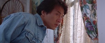 Movie still from “Rumble in the Bronx” (1995), directed by Stanley Tong – A person looking out of a window; Close Up shot, Low angle