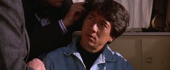 Movie still from “Rumble in the Bronx” (1995), directed by Stanley Tong – A person putting a hair brush on a man's hair; Close Up shot, Over the shoulder angle