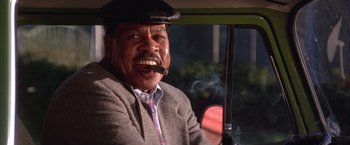 Movie still from “Rumble in the Bronx” (1995), directed by Stanley Tong – An older man sitting in the driver's seat of a car; Close Up shot, Low angle