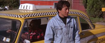 Movie still from “Rumble in the Bronx” (1995), directed by Stanley Tong – A man standing in front of a yellow taxi cab; Medium shot, Low angle