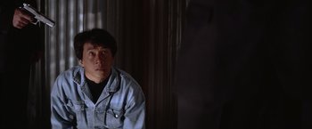 Movie still from “Rumble in the Bronx” (1995), directed by Stanley Tong – A man sitting in front of a window in the dark; Close Up shot, Over the shoulder angle