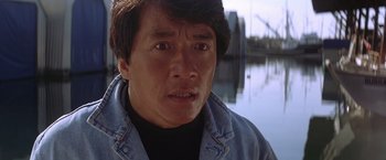 Movie still from “Rumble in the Bronx” (1995), directed by Stanley Tong – A person wearing a jean jacket near a body of water; Close Up shot, Low angle