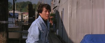 Movie still from “Rumble in the Bronx” (1995), directed by Stanley Tong – A man wearing a jean jacket walking down a street; Close Up shot, High angle