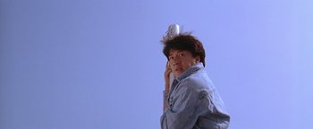 Movie still from “Rumble in the Bronx” (1995), directed by Stanley Tong – A man holding a cell phone up to his head; Medium shot, Low angle