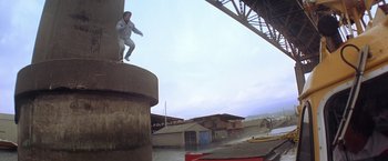 Movie still from “Rumble in the Bronx” (1995), directed by Stanley Tong – A man riding a skate board on top of a building; Extreme Wide shot, Low angle