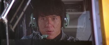 Movie still from “Rumble in the Bronx” (1995), directed by Stanley Tong – A man with a headset is sitting in an airplane; Close Up shot, Low angle