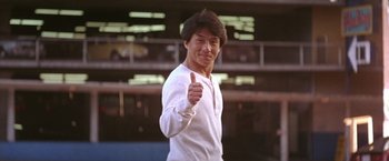 Movie still from “Rumble in the Bronx” (1995), directed by Stanley Tong – A man giving a thumbs up while wearing a white shirt; Medium shot, Low angle