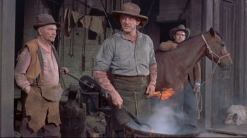 Movie still from “Run for Cover” (1955), directed by Nicholas Ray – A group of men standing next to each other in front of a fire; Medium shot, Low angle