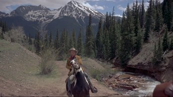 Movie still from “Run for Cover” (1955), directed by Nicholas Ray – A man riding a horse on a dirt road near a forest; Wide shot, Low angle