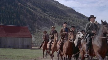 Movie still from “Run for Cover” (1955), directed by Nicholas Ray – A group of men riding horses down a dirt road; Wide shot, Low angle