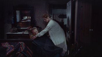 Movie still from “Run for Cover” (1955), directed by Nicholas Ray – A man in a white robe is holding a woman in her arms; Medium shot, High angle