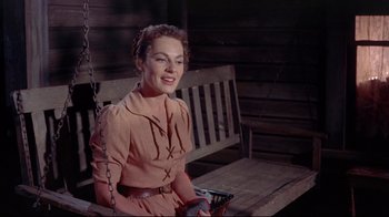 Movie still from “Run for Cover” (1955), directed by Nicholas Ray – A woman sitting on top of a wooden swing; Medium shot, High angle