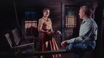 Movie still from “Run for Cover” (1955), directed by Nicholas Ray – A woman in a dress is holding a basket; Medium shot, Low angle