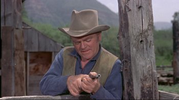 Movie still from “Run for Cover” (1955), directed by Nicholas Ray – An older man in a hat holding a gun; Medium shot, Over the shoulder angle