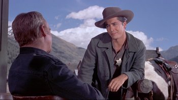Movie still from “Run for Cover” (1955), directed by Nicholas Ray – A man wearing a hat and a jacket talking to another man; Medium shot, Over the shoulder angle