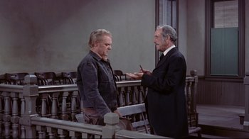 Movie still from “Run for Cover” (1955), directed by Nicholas Ray – Two men are talking to each other in front of a fence; Medium shot, High angle