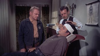 Movie still from “Run for Cover” (1955), directed by Nicholas Ray – A man getting his head shaved while another man watches; Medium shot, Over the shoulder angle