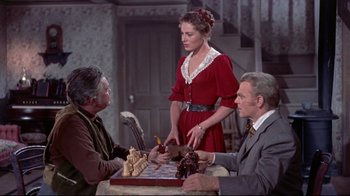 Movie still from “Run for Cover” (1955), directed by Nicholas Ray – Two men and a woman are playing a game of chess; Medium shot, Over the shoulder angle