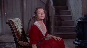Movie still from “Run for Cover” (1955), directed by Nicholas Ray – A woman in a red dress sitting on a chair; Medium shot, Low angle