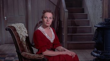 Movie still from “Run for Cover” (1955), directed by Nicholas Ray – A woman in a red dress sitting on a chair; Medium shot, Low angle