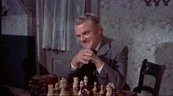 Movie still from “Run for Cover” (1955), directed by Nicholas Ray – A man sitting at a table with a chess set; Close Up shot, Over the shoulder angle