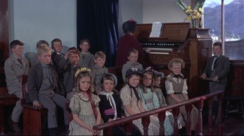 Movie still from “Run for Cover” (1955), directed by Nicholas Ray – A group of children sitting in front of an organ; Medium shot, High angle