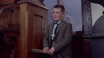 Movie still from “Run for Cover” (1955), directed by Nicholas Ray – A boy in a suit and tie holding a knife in his hand; Medium shot, Low angle