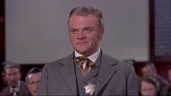 Movie still from “Run for Cover” (1955), directed by Nicholas Ray – An older man wearing a suit and tie; Close Up shot, Low angle