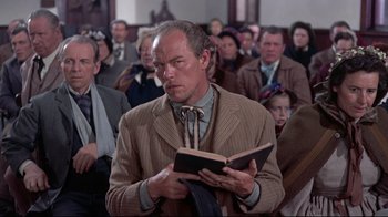 Movie still from “Run for Cover” (1955), directed by Nicholas Ray – A man is reading a book in front of a group of people; Medium shot, Low angle