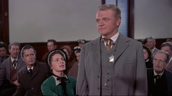 Movie still from “Run for Cover” (1955), directed by Nicholas Ray – An older man and a younger woman standing in front of a group of people; Medium shot, Low angle