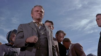 Movie still from “Run for Cover” (1955), directed by Nicholas Ray – A group of men standing next to each other in a field; Medium shot, Low angle