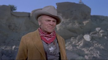 Movie still from “Run for Cover” (1955), directed by Nicholas Ray – An older man wearing a cowboy hat and a cowboy outfit; Medium shot, Low angle