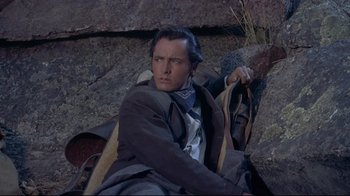 Movie still from “Run for Cover” (1955), directed by Nicholas Ray – A man sitting on the ground holding a shovel; Medium shot, Low angle