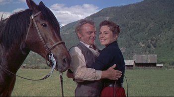 Movie still from “Run for Cover” (1955), directed by Nicholas Ray – A man and a woman hugging next to a horse; Medium shot, Low angle