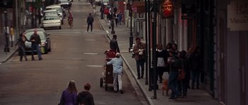 Movie still from “Runaway Jury” (2003), directed by Gary Fleder – People walking down a sidewalk near a building; Extreme Wide shot, High angle